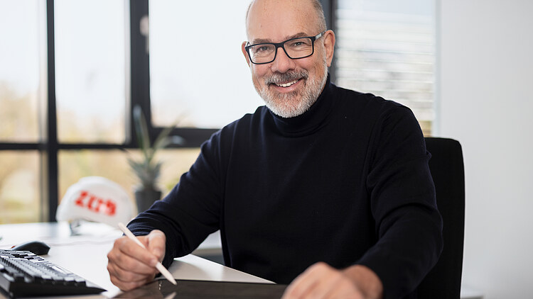 An employee with a tablet is sitting at a desk