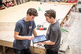 Zwei Auszubildende arbeiten gemeinsam mit Tablet