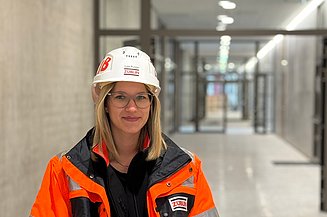 Junge Frau in ZÜBLIN-Arbeitsschutzkleidung auf deiner Baustelle